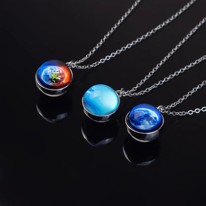 Three planet-themed necklaces on a black background